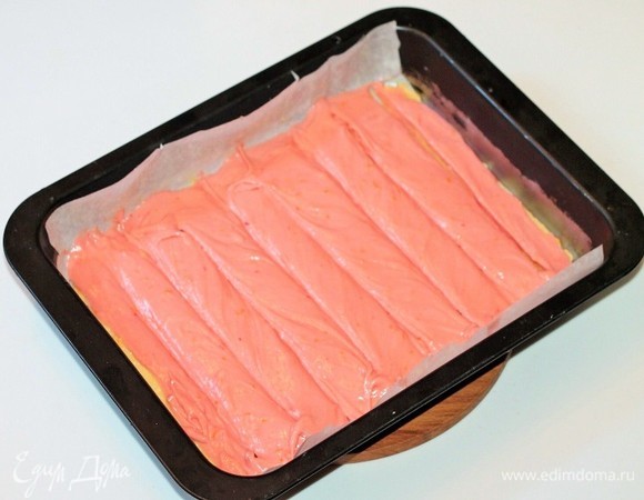 Затем кладем розовое тесто и также выравниваем слой. Можно тупой частью столовой ложки прочертить на тесте глубокие полосы. Отправляем противень с заготовкой в хорошо разогретую духовку и выпекаем минут 15, все зависит от размера вашего противня. Выпекается корж очень быстро, не пересушивайте.