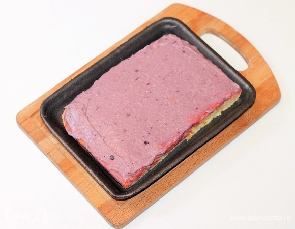 Приготовленному коржу даем время остыть минут 10. Разрезаем корж на 2 части. Щедро смазываем первую часть кремом.