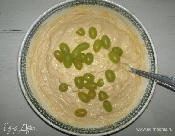 Порциями добавлять виноград в тесто и перемешивать.