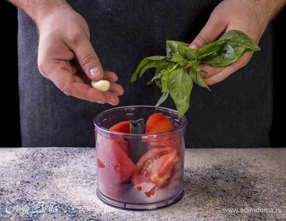 Чеснок очистите. В чашу блендера выложите помидоры, чеснок, базилик. Пробейте все блендером до состояния пюре.