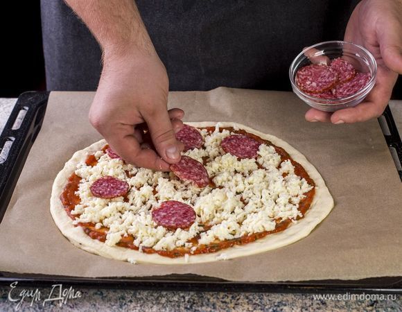 Выложите нарезанную моцареллу и колбасу.