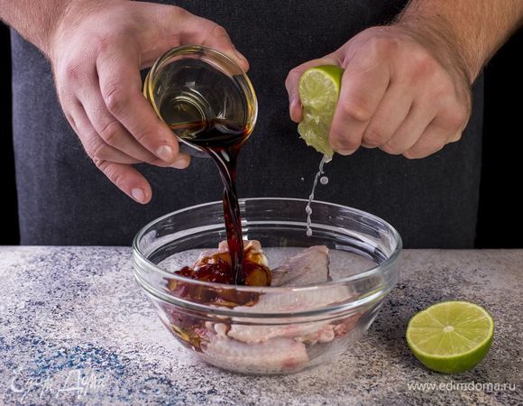 Куриные крылышки переложите в глубокую емкость, добавьте сок лайма и соевый соус.