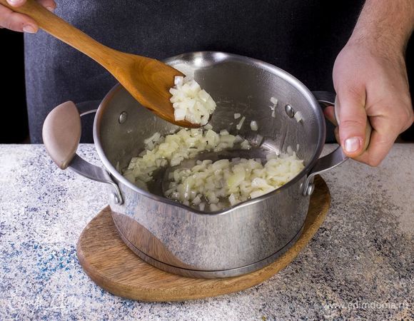 В кастрюле растопите сливочное масло. Добавьте мелко нарезанный лук. Обжарьте его на среднем огне до золотистого цвета.