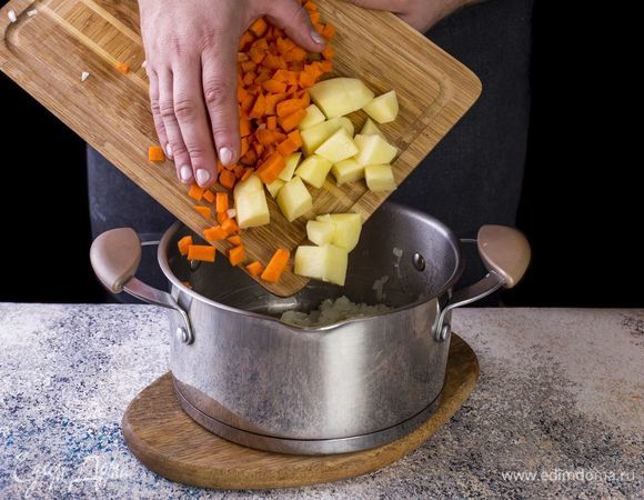 Добавьте нарезанные морковь и картофель в кастрюлю. Слегка обжарьте.