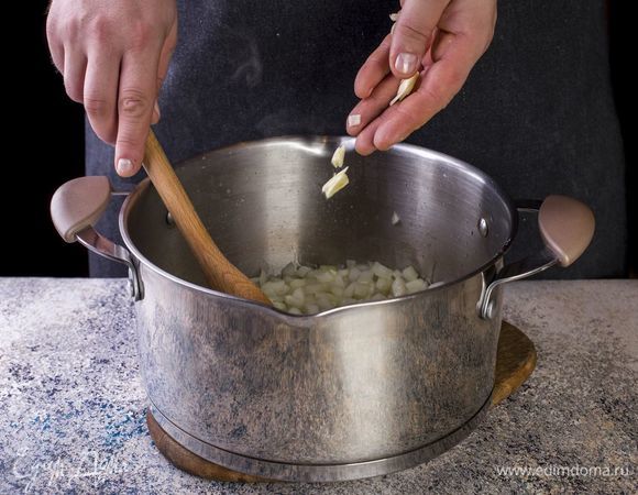 Налейте в кастрюлю масло. Добавьте мелко нарезанный чеснок и лук. Обжарьте до золотистого цвета.