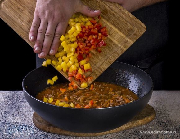 Перцы нарежьте мелкими кубиками, добавьте в сковороду.