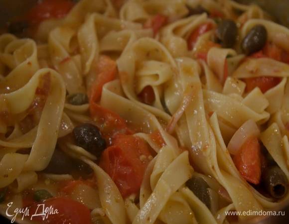 В сковороду с луком и чесноком добавить помидоры, все перемешать, затем добавить аджику, оливки, каперсы, еще раз перемешать. Затем шумовкой или щипцами переложить в сковороду макароны, немного прогреть и выключить огонь.