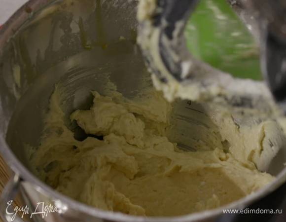 В чаше комбайна соединить 125 г предварительно размягченного сливочного масла и 100 г сахара, взбить все в однородную массу, затем, продолжая взбивать, по одному ввести яичные желтки, всыпать немного муки, добавить ванильный экстракт и соль, всыпать еще немного муки, влить молоко, всыпать кокосовую стружку, оставшуюся муку и вымешать тесто еще немного.