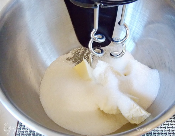В чашу миксера положите мягкое масло и всыпьте сахар. Перемешайте до пышной массы.