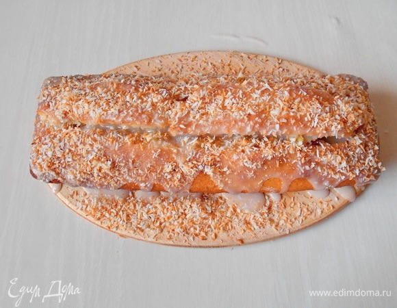 Полейте глазурью поверхность кекса и посыпьте обжаренной кокосовой стружкой.