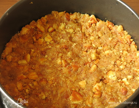 Делаем основу для пирога: плотно выкладываем слой печенья в смазанную форму.