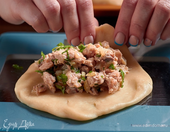 Каждый кусочек растянуть в лепешку. В центр лепешки добавить фарш.