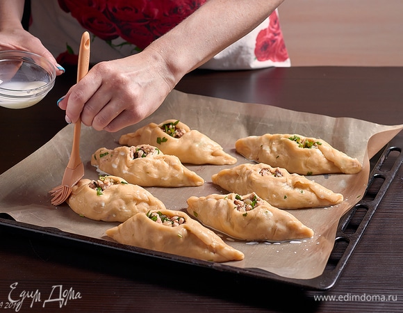 Заготовки уложить на противень, смазать молоком.