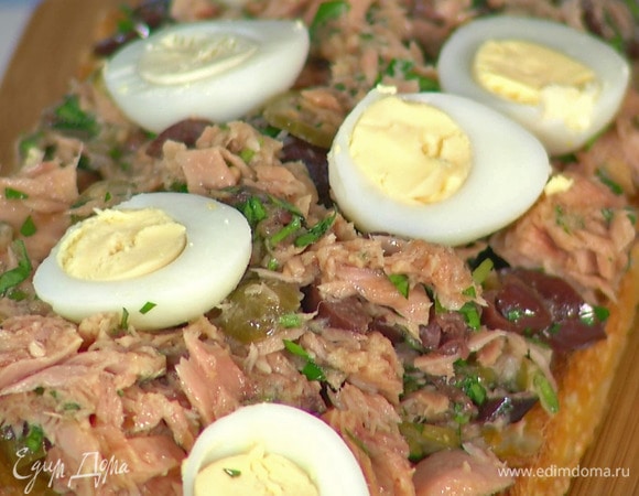 На одну часть чиабатты выложить салат с тунцом, перепелиные яйца, нарезанные дольки помидора и пару анчоусов. Накрыть сверху второй частью хлеба.