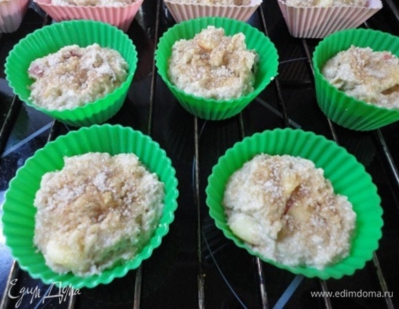 Сюда же влить кефир, перемешать и оставить на 15 минут. Включить духовку для разогрева до 190–200°C. К тесту добавить соду, смешанную с 1 ст. л. кефира, хорошо перемешать и разложить по формочкам. Посыпать сверху смесью сахара с корицей.