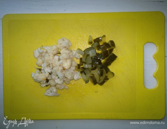 Маринованную цветную капусту и соленый огурец обсушить. Капусту разобрать на мелкие соцветия, огурец нарезать ломтиками.
