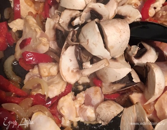 Когда куриное филе начало подрумяниваться с обеих сторон, добавляем в сковороду крупно нарезанные шампиньоны. Перемешиваем, солим, перчим. Перец в нашем доме больше нравится свежесмолотый в грейдере, но подходит и молотый из пакета.