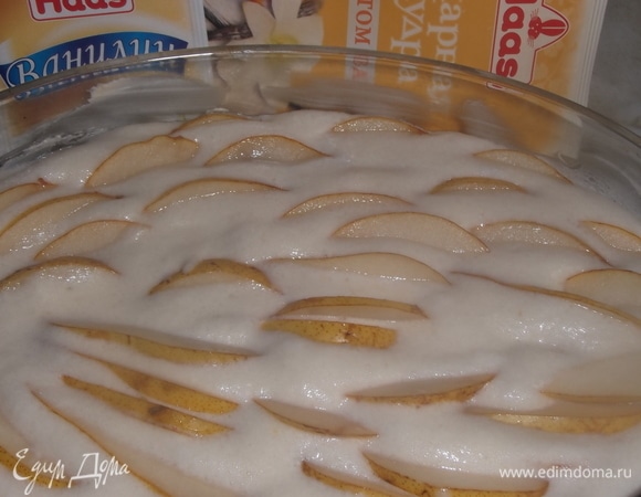 Форму смазать сливочным маслом. Залить тестом. Сверху выложить нарезанные на дольки груши. Поставить в разогретую духовку.