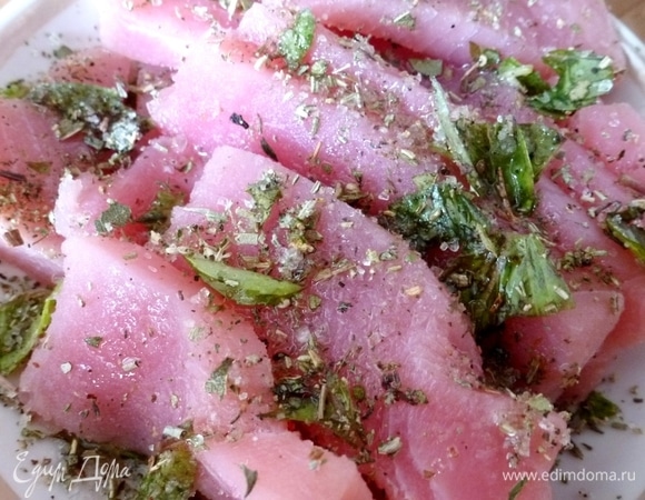 Посыпать рыбу специями с солью. Перемешать, чтобы всем кусочкам досталось соли.