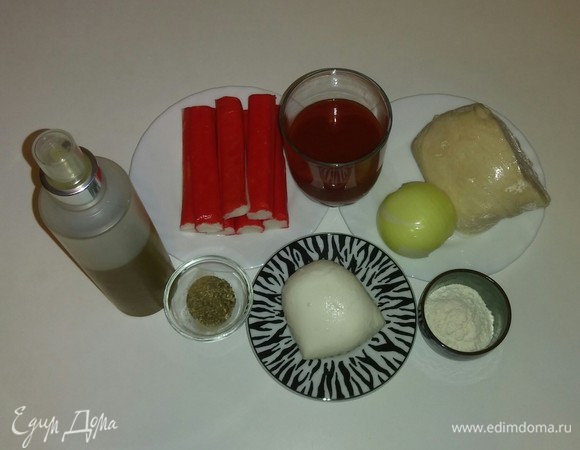 Собираем вместе все необходимые ингредиенты. Я использую кефирное тесто, которое было приготовлено заранее и заморожено. Поэтому перед приготовлением необходимо достать тесто из морозилки заранее и разморозить. Рецепт теста указан здесь: https://www.edimdoma.ru/retsepty/124412-kefirnoe-testo-dlya-pitstsy. На всякий случай коротко напомню. Ингредиенты для 1 порции теста (для формы диаметром 26 см): 150 г блинной муки, 100 мл 1% кефира, щепотка соли и щепотка сахара. Перемешать все вместе. Если тесто получается жидковатым, то можно еще чуть-чуть добавить муки. Для этой пиццы я использовала крабовые палочки. Перед приготовлением их необходимо разморозить.