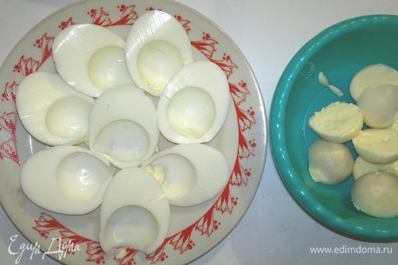 Оставшиеся яйца разрезать пополам и разделить на белки и желтки.