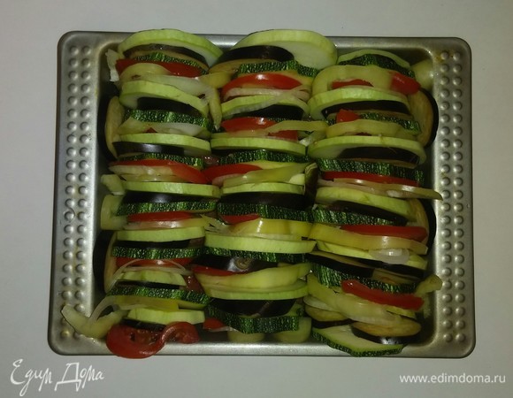 Укладываем в форму порезанные овощи в следующем порядке: кабачок, баклажан, цукини, помидор, перец и лук. И выкладываем так овощи до заполнения всей формы.