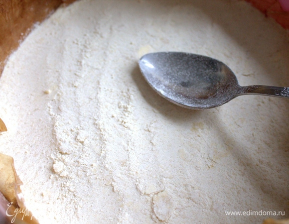 Половину или чуть больше крошки утрамбовать в форме на бумаге для выпечки.