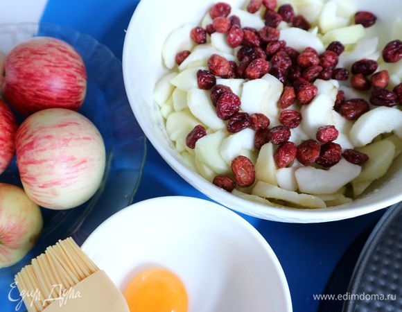 На мелкой терке натереть цедру лимона. Выжать лимонный сок. Яблоки очистить от кожуры, разрезать на четвертинки, удалить семенную часть. Нарезать тонкими ломтиками. Поместить яблоки в посуду с лимонным соком и цедрой, добавить сахар, ванильную эссенцию, сушеную бруснику.