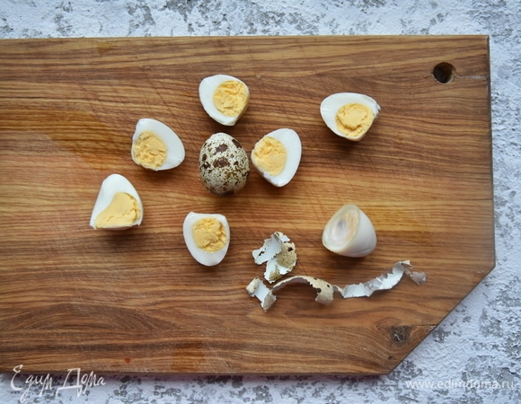 Перепелиные яйца отварить в в воде в течение 5 минут после закипания. Залить холодной водой. Очистить от скорлупы и разрезать пополам.