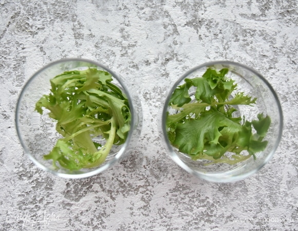 Для оформления салата подготовить стеклянные бокалы. Листья салата хорошо промыть и тщательно просушить. На дно бокалов выложить веточки салата.