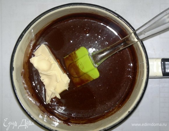 В слегка остывшую шоколадную массу добавить сливочное масло, перемешать. Остудить глазурь до комнатной температуры.
