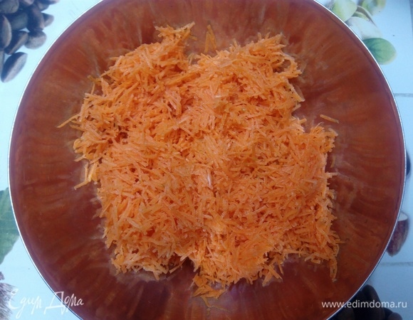 Духовку ставим разогреваться на 180°C. В это время натираем морковь на терке тонкой соломкой. И рубим орехи до размера 3–5 мм.