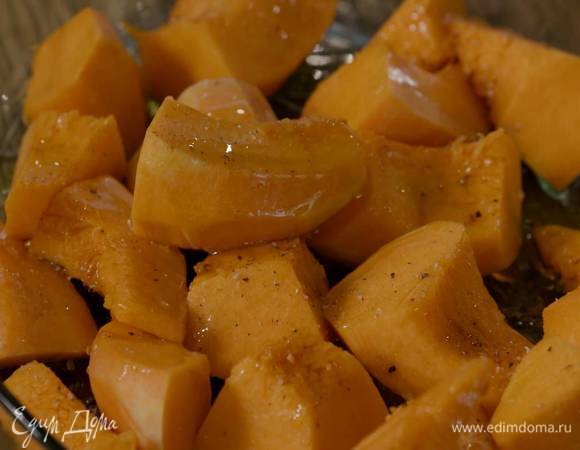 Тыкву почистить, нарезать небольшими кусочками и выложить в жаропрочную форму, затем слегка посолить, поперчить, полить кленовым сиропом и 1‒2 ст. ложками оливкового масла.