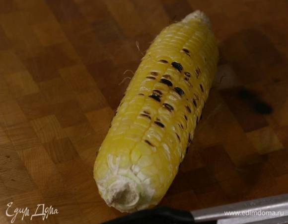 Кукурузу, удалив листья, жарить на сковороде-гриль до появления румяных полосок, затем ножом срезать зерна.