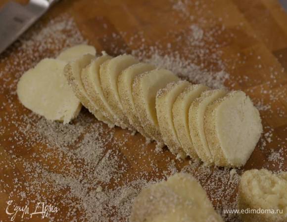 Оставшийся ванильный сахар высыпать на рабочую поверхность и прокатать колбаску из теста, так чтобы она покрылась сахаром. затем острым ножом нарезать тесто на кружки толщиной полсантиметра.