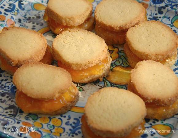 Смазать одно готовое печенье апельсиновым джемом и накрыть вторым.