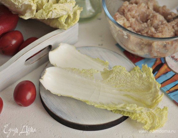 Китайскую капусту разбираем на листы и буквально на минутку опускаем каждый листок в кипящую подсоленую воду. Листья у салата нежные. Нам нужна мягкость, чтобы сформировать голубцы.