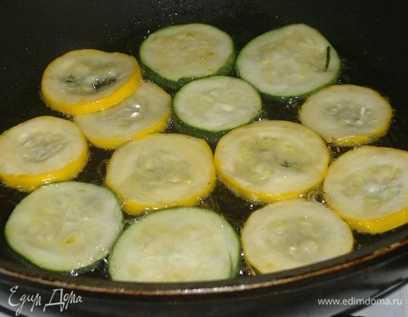 С цукини слить образовавшийся сок, обсушить бумажным полотенцем. В сковороде разогреть 3 ст. л. растительного масла и обжарить на нем цукини с двух сторон до румяности.