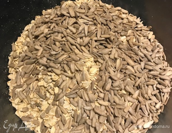 Овсяные хлопья смешать с семечками. Добавить масло с кленовым сиропом, чуть-чуть посолить и хорошо перемешать.