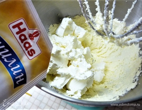 Приготовим крем. Взбиваем размягченное сливочное масло с сахаром до пышности, добавляем холодный творожный сыр, ванилин Haas, взбиваем еще 3–5 минут. Делим крем пополам.