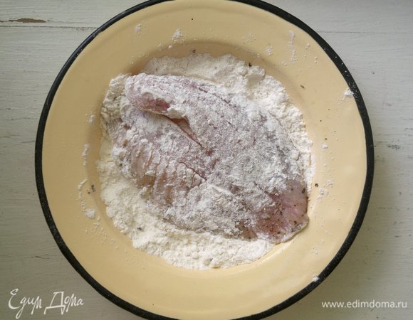 Филе тилапии обвалять в муке, излишки стряхнуть.