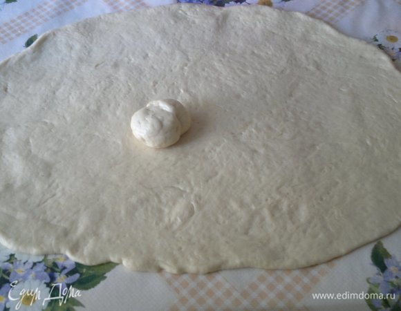 От теста отщипнуть небольшой кусочек. Остальное тесто раскатать в овальный пласт толщиной примерно 0,5 см. На этом этапе нужно постелить на стол бумагу для выпечки и раскатывать прямо на ней, так как в дальнейшем, как оказалось, будет очень трудно перенести кулебяку на противень.