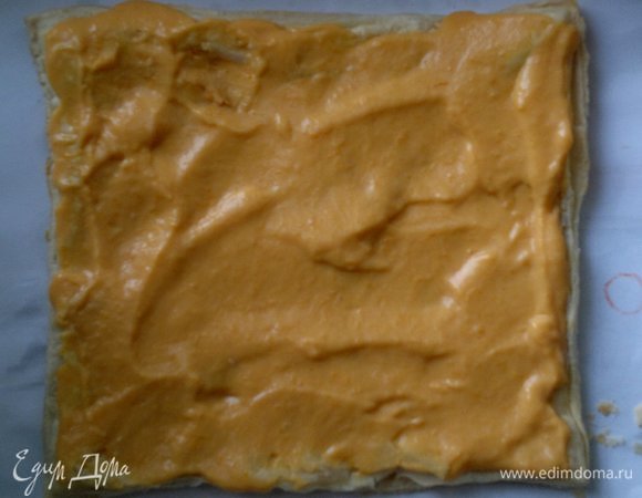 На пласт теста выложить часть крема, разровнять лопаткой. На крем положить второй пласт теста.