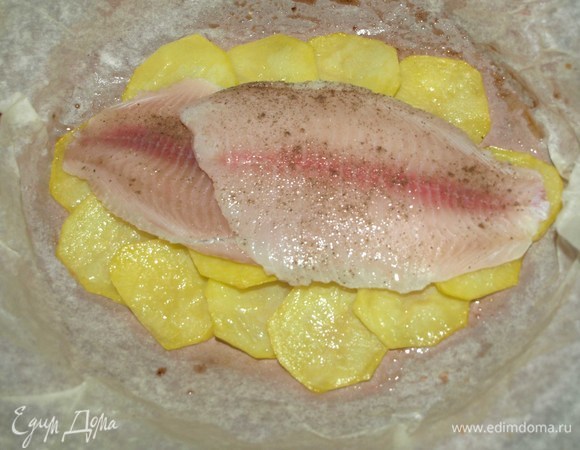 Достаем из духовки противень с картофелем, выкладываем на него филе тилапии и отправляем в духовку на 10 минут.