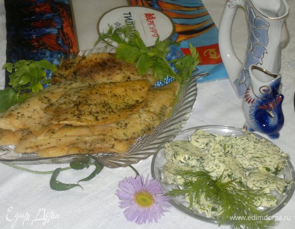 Достать из морозилки пряное масло, нарезать на кусочки. Подать на стол горячее филе, украсив его зеленью и овощами, и пряное масло.