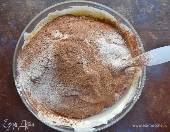 Просеять муку и добавить ее к взбитым яйцам вместе с какао-порошком.