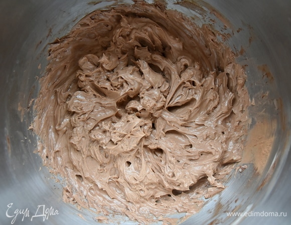 Масло взбить до пышного состояния и, продолжая взбивать, порциями влить в него сироп из сгущенного молока и яиц. С последней порцией сиропа всыпать какао-порошок и ванилин Haas.