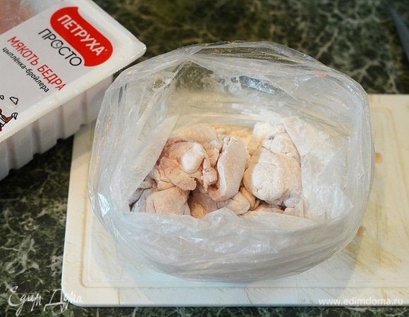 Добавьте кусочки курицы и хорошо потрясите пакет, чтобы каждый кусочек запанировался в крахмале.