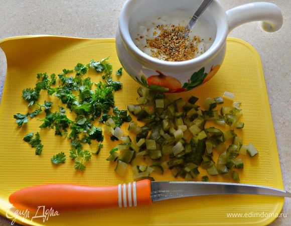 Тем временем подготовьте соус. Для этого смешайте творожный сыр, чуть-чуть добавьте сок лимона, мелко нарезанную петрушку и соленый огурец. Приправьте специями для соуса дзадзики и паприкой. Если у вас нет таких специй (для приготовления дзадзики), то добавьте сухой чеснок, соль и сухой укроп по вкусу.