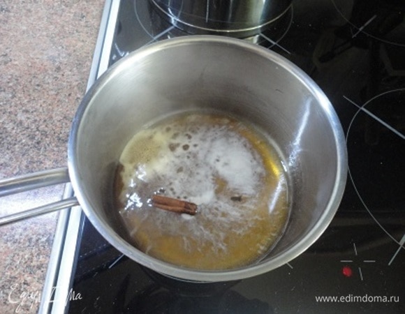 Пока пирог печется, приготовьте сироп. В кастрюльке смешайте мед (3 ст. л.), сок половины апельсина, воду и специи. Доведите до кипения и оставьте остывать.